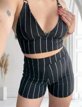 Conjunto de top y short negro con rayas verticales blancas. El top es tipo corpiño con breteles finos y el short es de tiro alto.