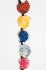 Collar con cordón negro y dijes de conchas marinas de colores con borde de strass. Incluye un dije dorado en forma de hoja.