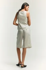 Chaleco sastrero color crudo con escote recto, breteles finos y costuras moldeadoras adelante y atrás. Cierre frontal con botones hasta la cintura y forro interior.