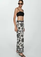 Pantalón wide leg de viscosa con estampado floral en blanco y negro. Tiene cintura elástica, dos bolsillos laterales y diseño largo.