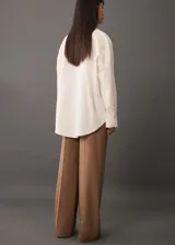 Camisa color crema de corte oversize con bordado floral en hombros y bolsillos.