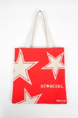 Bolso tote de tela con estampado de rayas verticales rosadas y blancas, laterales y asas en color beige. Presenta la palabra "BONJOUR" en verde en el centro y "INDIAN" en la parte inferior.