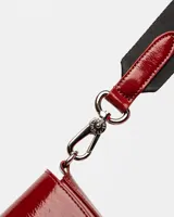 Mini bolsa de cuero charol arrugado color bordó con cierre frontal y correa ajustable.