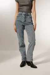 Pantalón de jean celeste con diseño de líneas curvas bordadas y strass. Corte recto y tiro alto.