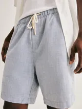 Bermuda de tela texturizada en color gris, con cintura elástica y cordón ajustable.