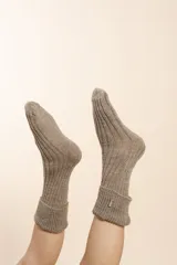 Medias tejidas a máquina en punto elástico, color crudo. Confeccionadas en lana fina sin teñir.