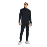 Conjunto deportivo Under Armour gris con detalles en negro. Incluye campera con cierre y pantalón con cintura elástica y cordón ajustable. Ambos con logo de la marca en el pecho y en la pierna.