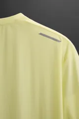 Camiseta deportiva color amarillo claro confeccionada en tejido técnico ligero y elástico. Cuenta con cuello redondo, manga corta, costuras termofijadas y estampaciones reflectantes en la espalda.