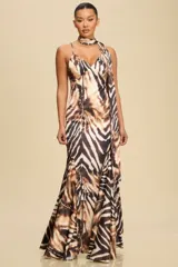 Vestido largo con estampado animal print en tonos marrones y blancos. Diseño con escote halter y abertura lateral.