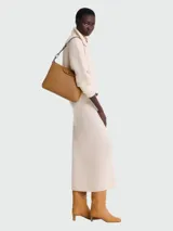 Bandolera Longchamp modelo Le Pliage Xtra, color marrón claro, con correa de hombro ajustable, cierre con solapa y botón a presión.