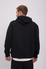 Hoodie negro con capucha y manga larga, de corte holgado y estampado ovalado en el pecho.