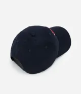 Gorra de sarga de algodón color marrón oscuro con visera curva y ajuste trasero. Presenta un bordado frontal con las letras 'NYC' en estilo universitario con detalles en rojo y blanco, flanqueadas por los números '19' y '86' y tres estrellas blancas debajo.