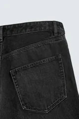 Pantalón de jeans de algodón, corte baggy fit, tiro medio, con efecto lavado en tonos grises y verdes. Presenta cinco bolsillos y cierre frontal con cremallera y botón.