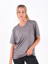 Remera deportiva gris de manga corta, con cuello redondo y tejido texturizado de microperforaciones.