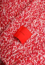 Sweater de tejido de punto color rojo con textura jaspeada, de corte recto y cuello redondo.