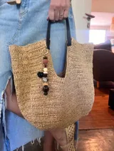 Colgante decorativo para bolso o llavero, compuesto por una cadena metálica con un conjunto de cuentas de diferentes formas, colores y texturas, incluyendo piedras naturales y cuentas de madera.