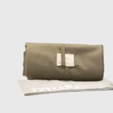 Lona de algodón color verde militar, enrollada y atada con una tira de cuero sintético color crema. Incluye bolsa de tela haciendo juego.