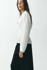 Pantalón negro de tiro alto con bolsillos delanteros, pinzas y corte ancho.
