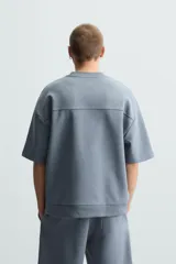 Sudadera relaxed fit color crudo confeccionada en tejido interlock de algodón con elasticidad, cuello redondo, manga corta y bajo acabado en rib.