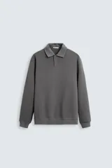 Polo gris oscuro de manga larga, corte regular fit, confeccionado en tejido de algodón con elasticidad y estructura. Cuello solapa con cierre frontal de botonadura y acabados con rib.