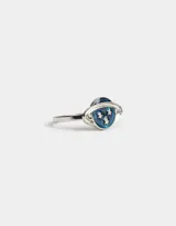 Anillo plateado con diseño de planeta esmaltado en azul y estrellas plateadas.