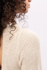 Vestido corto color crema, tejido de punto con lurex, escote redondo y mangas largas acampanadas.