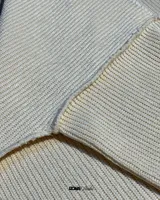 Buzo color crema de lana premium con textura acanalada y costuras expuestas.