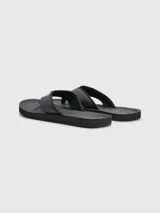 Ojotas negras Tommy Hilfiger con tira ancha de poliuretano acolchada y suela de goma EVA. Detalle de cinta distintiva con los colores de la marca en la tira.