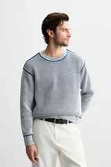Jersey de punto con cuello redondo y manga larga. Diseño a rayas verticales en color azul marino y blanco.