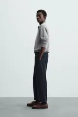 Polo marrón de corte relaxed fit, tejido en punto de algodón. Tiene cuello solapa con cierre frontal de botonadura, manga larga y acabados en rib.