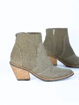 Bota corta color verde oliva de gamuza, con puntera levemente puntiaguda, cierre lateral y taco de madera.