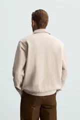 Polo manga larga negro de algodón con elasticidad y estructura. Cuello solapa con cierre frontal de botonadura y acabados con rib.