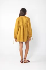 Vestido corto azul con escote con cordones, mangas largas abullonadas y corte evasé.