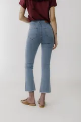 Pantalón jean cropped azul con corte acampanado y ruedo desflecado.