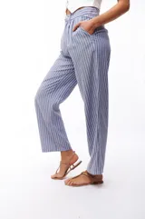 Pantalón de vestir a rayas verticales azules y blancas, de corte recto y tiro alto.