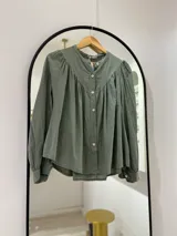 Camisa verde oliva de manga larga con puño, cuello mao y cierre frontal con botones.