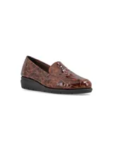 Zapato mocasín de cuero sintético color negro con textura símil cocodrilo.