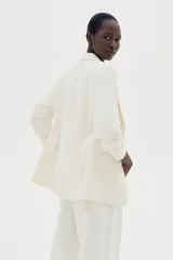 Blazer entallada color blanco, confeccionada en mezcla de viscosa. Modelo con hombreras, solapas de muesca, mangas tres cuartos fruncidas y bolsillos delanteros con solapa. Sin cierre y forrado.