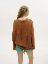 Sweater amarillo mostaza de punto calado con detalles rasgados y flecos bordados con canutillos de madera. Tiene cuello y puños bordados en crochet y pespunte bordado en hilo grueso en la sisa.
