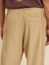 Pantalón de pana color caqui, de corte recto y tiro medio, con cintura elástica y bolsillos laterales.