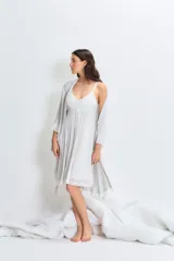 Bata gris claro melange de modal jersey con detalle de puntilla en mangas y ruedo. Tiene lazo para ajustar en la cintura y detalle bordado en el pecho.