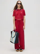 Pantalón de algodón color rojo, de corte holgado y pierna ancha, con pretina elástica y rayas bicolores al costado.