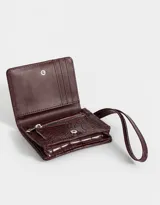 Billetera negra de cuerina con textura efecto croco y correa lateral.