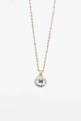 Cadena dorada de acero quirúrgico con dije circular con una piedra blanca rodeada de pequeñas circonitas.