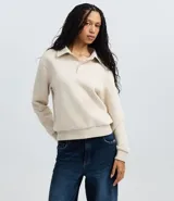 Saco femenino cerrado de algodón con felpa más sostenible, color beige. Presenta cuello polo con abotonado parcial, manga larga y bajo ajustado.