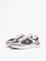 Zapatillas Tommy Hilfiger de diseño color block con paneles de malla, exterior e interior de poliéster, plantilla extraíble de poliuretano y caucho termoplástico, suela de EVA, panel metálico en el talón y monograma TH en la lengüeta y lateral.