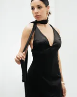 Vestido corto negro de seda con escote halter pronunciado y espalda descubierta. Incluye lazo al cuello.