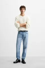 Pantalón de jean celeste de corte slim fit y tapered, con cinco bolsillos, efecto lavado y cierre frontal con cremallera y botón.