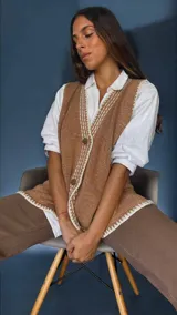 Chaleco tejido a mano con algodón y lurex, con escote en V, bordado y con botones. Terminaciones en crochet y bordados hechos a mano con lana merino.