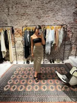 Pollera midi negra de satén con frunces laterales y abertura en la pierna.